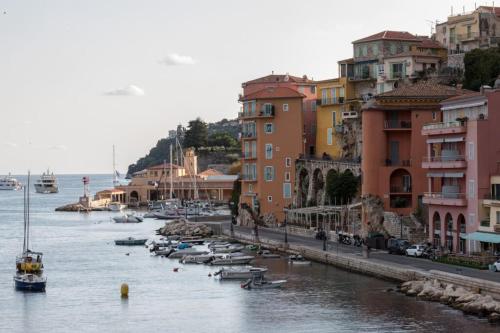 un groupe de bateaux dans l'eau à côté des bâtiments dans l'établissement MARINIÈRES - Incredible view over the Bay, à Villefranche-sur-Mer