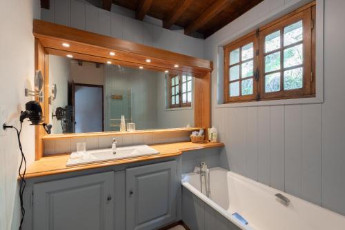 une salle de bain avec un lavabo, une baignoire et un miroir dans l'établissement Maison Ty Sioul - Vue montagne, à Aydius