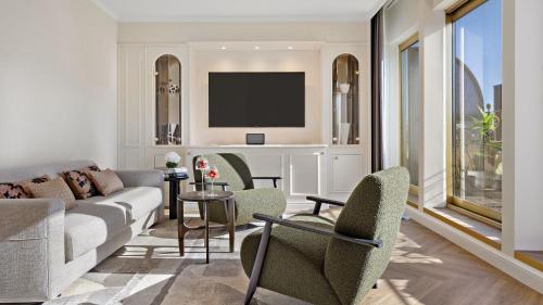 a living room with a couch and a tv at Hotel Bristol Berlin in Berlin