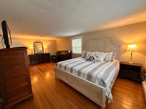 a bedroom with a bed and a dresser and a television at 3 Shore Road Extension West Harwich Cape Cod - - A Shore Thing in West Harwich