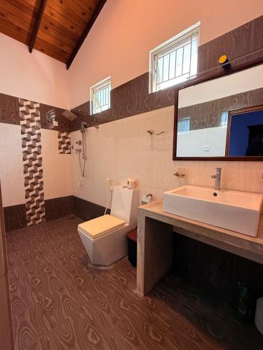 a bathroom with a toilet and a sink at Kanapathiy Rest House in Trincomalee