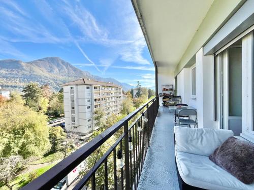 d'un balcon avec un canapé et une vue sur un bâtiment. dans l'établissement Appartement proche Lac ANNECY, à Annecy