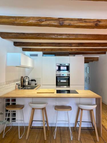 - une cuisine avec un comptoir en bois et des tabourets dans l'établissement Exceptional location between lake and pedestrian street, à Annecy