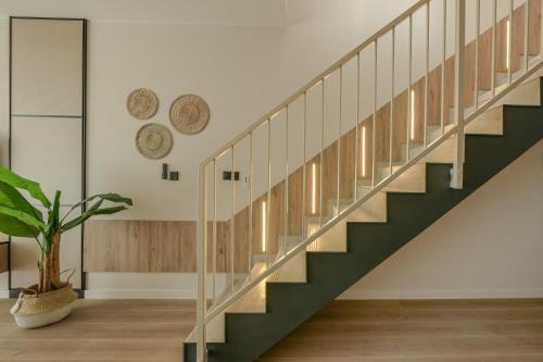 a staircase in a house with green and white stairs and a plant at Apartamenty Florina Q4Apartments in Łeba