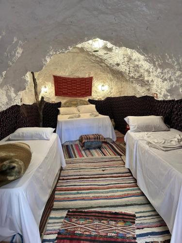a room with two beds in a cave at Dar Fatma Toujane in Tūjān