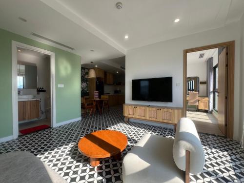 a living room with a tv and a table at Gold Coast Apartment Seaview in Nha Trang