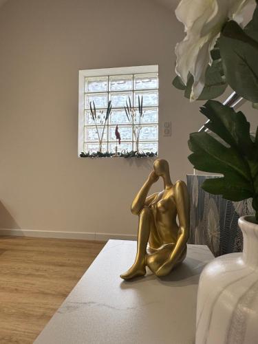 une statue en bronze assise sur une table dans une pièce avec une fenêtre dans l'établissement Firmin Gaillard, à Brive-la-Gaillarde