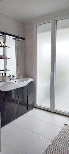 une salle de bain avec un lavabo et une grande fenêtre dans l'établissement 3 chambres à 200m mer et commerces, à La Bernerie-en-Retz