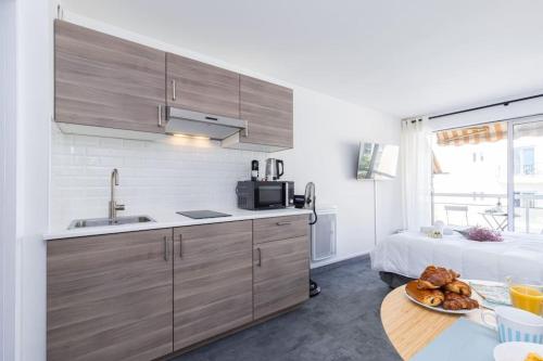 - une cuisine avec un évier et une table avec un lit dans l'établissement GROSSO 4 - Studio with Balcony - Near the Sea, à Nice
