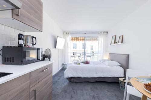 - une cuisine blanche avec un lit dans une chambre dans l'établissement GROSSO 4 - Studio with Balcony - Near the Sea, à Nice