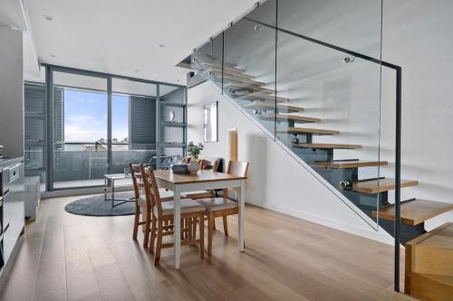 a dining room with a table and a staircase at 58A 2Storey Abnb-Style Apt with 2BR Plus Parking, Walk to Ashfield Mall and Train in Sydney