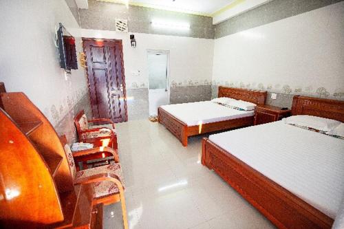 a room with two beds and a tv in it at Hotel Trung khanh in Quy Nhon