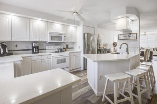 a white kitchen with white cabinets and white appliances at Loggerhead 282 condo in Sanibel