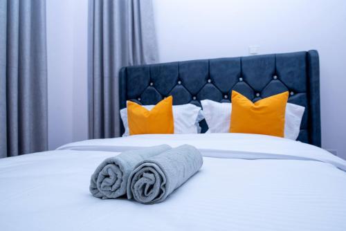 a bed with two rolled towels on top of it at Quiet a Gem off Thika Highway in Ruiru