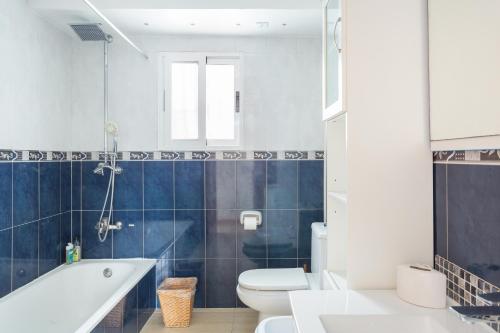 Un baño con bañera, inodoro y lavabo. en Maison Oliva, en La Font D´En Carròs