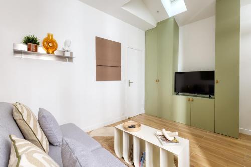 un salon avec un canapé et une table dans l'établissement Appartement proche Tour Eiffel, à Paris