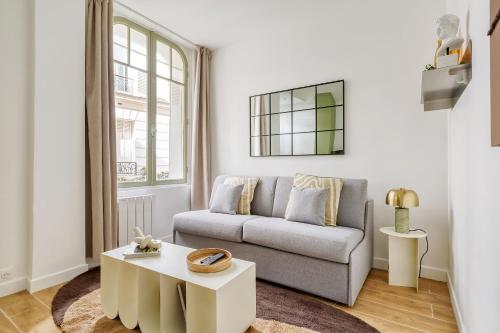 un salon avec un canapé et une table dans l'établissement Appartement proche Tour Eiffel, à Paris