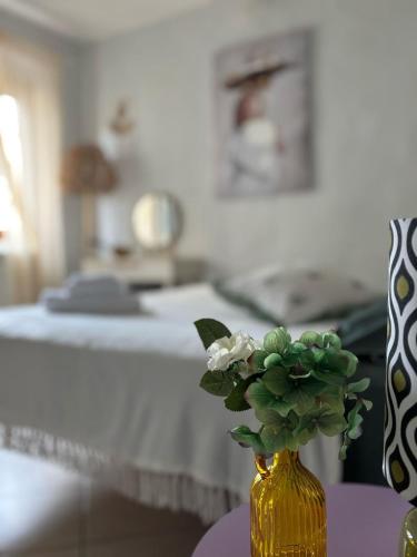 a yellow vase with flowers on a table in a bedroom at Un piede nel Chianti in Cavriglia