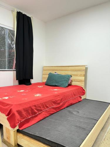a bedroom with a bed with a red blanket at Casa temporada in Camaçari