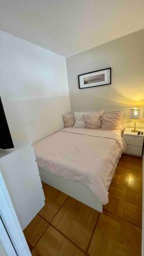 - un lit blanc dans une chambre dotée d'un mur blanc dans l'établissement Le Charmetta Residence, à Nice