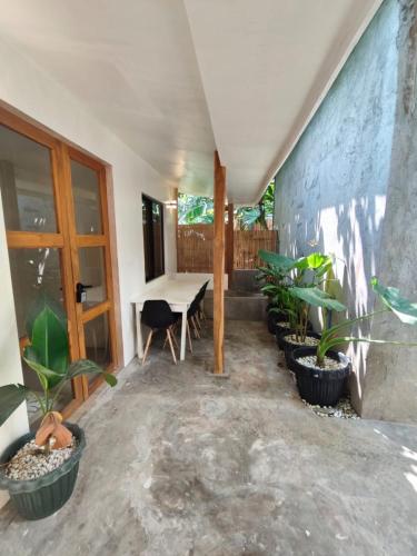 une chambre avec une table et des plantes en pots dans l'établissement Caalan Cottage, à El Nido