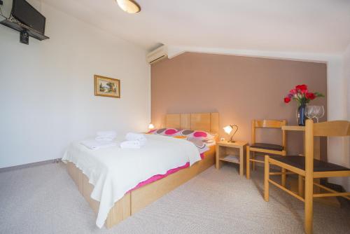 a bedroom with a bed and a table and a chair at Plitvicka Vrela in Grabovac