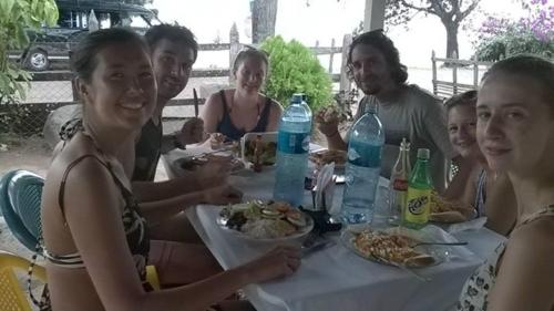a group of people sitting at a table eating food at Hostal La Cascada San Ramón in Mérida