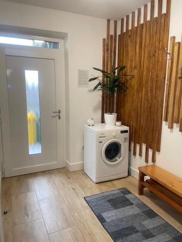 a laundry room with a washing machine and a door at Vila Mima in Nová Lesná