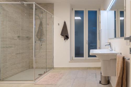 a bathroom with a glass shower and a sink at Villa Petra with a pool in Manerba del Garda