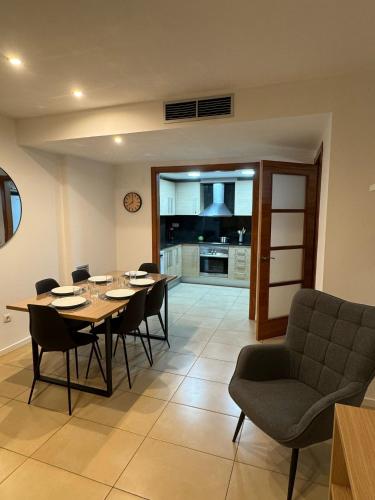 a dining room with a table and chairs and a kitchen at Cala Paula in Lloret de Mar