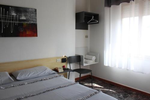 a bedroom with a bed and a chair and a window at B&B Cardedu in Cardedu