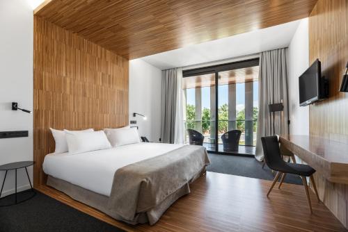 a hotel room with a bed and a desk at Pousada Ribadumia in Ribadumia