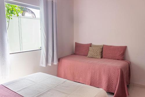 a bedroom with two beds and a window at Casa Privativa de 3 Quartos com Piscina com Aquecimento Solar a 800m das Praias de Taperapuan, Ar Condicionado, WiFi 110Mbps, Churrasqueira, Garagem para 02 Carros in Porto Seguro