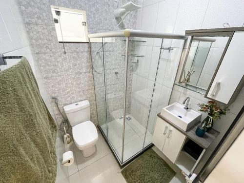 a bathroom with a shower and a toilet and a sink at Casa Privativa de 3 Quartos com Piscina com Aquecimento Solar a 800m das Praias de Taperapuan, Ar Condicionado, WiFi 110Mbps, Churrasqueira, Garagem para 02 Carros in Porto Seguro