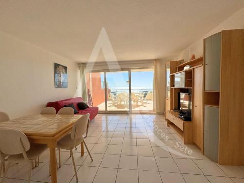 un salon avec une table de salle à manger et une cuisine dans l'établissement 2 CHAMBRES, LARGE TERRASSE 1ERE LIGNE MER, PISCINE, à Sète