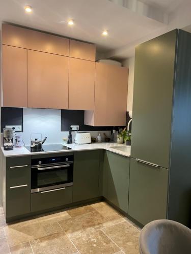 une cuisine avec des armoires vertes et des comptoirs blancs dans l'établissement A Casa Laetizia, à Eccica-Suarella