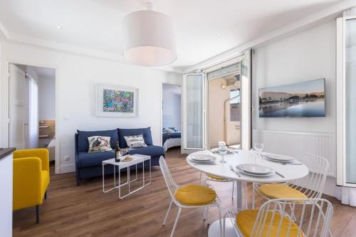 un salon avec une table, des chaises et un canapé dans l'établissement SPITALIERI- Sunny Terrace with view -New Apartment, à Nice