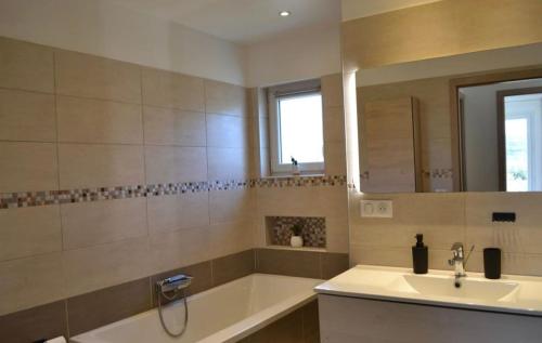 une salle de bain avec une baignoire, un lavabo et un miroir dans l'établissement Casa EliaEmie Bonifacio, à Bonifacio