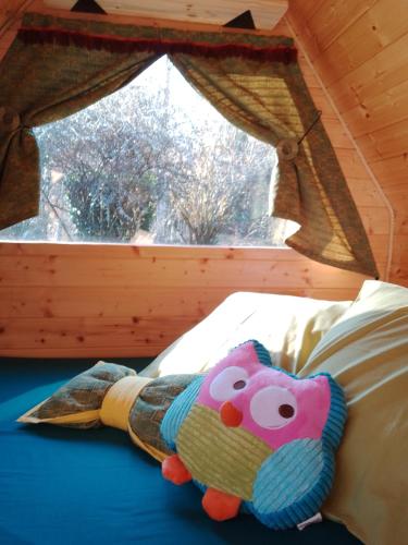 un animal farci posé sur un lit devant une fenêtre dans l'établissement La cabane de Moïra, à Xertigny