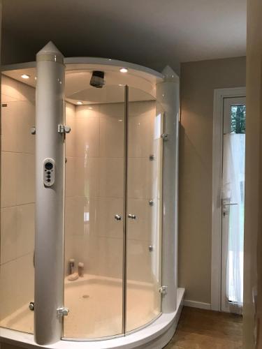 une douche avec une cabine en verre dans une salle de bain dans l'établissement Domaine du Chêne du Vert, à Yzernay