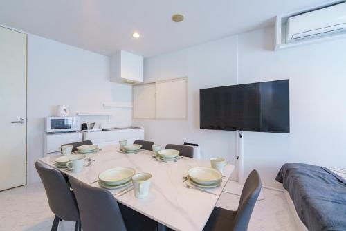 a dining room with a table with chairs and a television at feel Akihabara STAY in Tokyo
