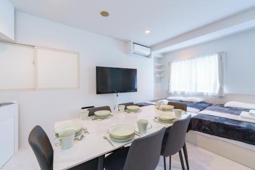a white room with a table and chairs and a bed at feel Akihabara STAY in Tokyo