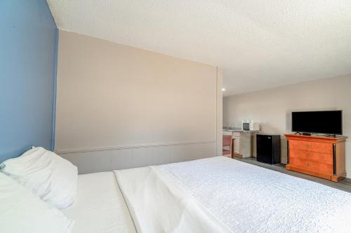 a bedroom with a bed and a flat screen tv at Cypress Inn Motel By OYO West Monroe I-20 in Monroe