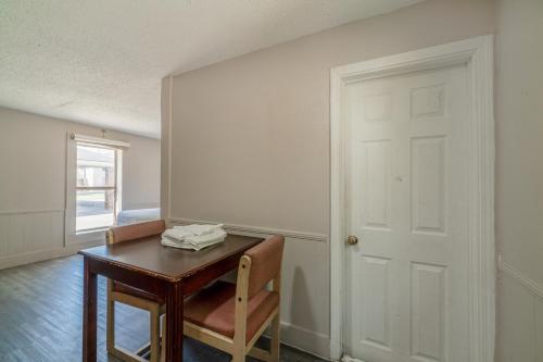 a room with a table and a chair and a door at Cypress Inn Motel By OYO West Monroe I-20 in Monroe