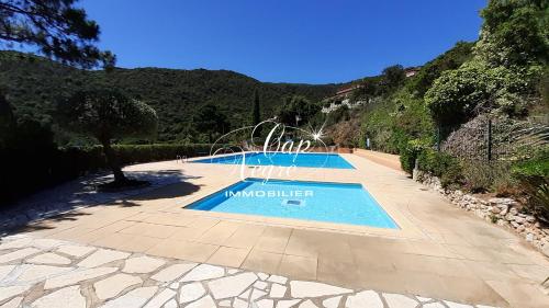 une piscine au milieu d'une montagne dans l'établissement mazet t2 pour 4 personnes avec jardin vue mer au mas de pramousquier, au Lavandou