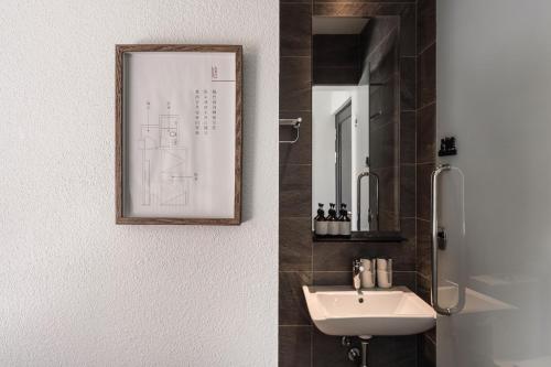 a bathroom with a sink and a picture on the wall at SI Hotel in Taichung