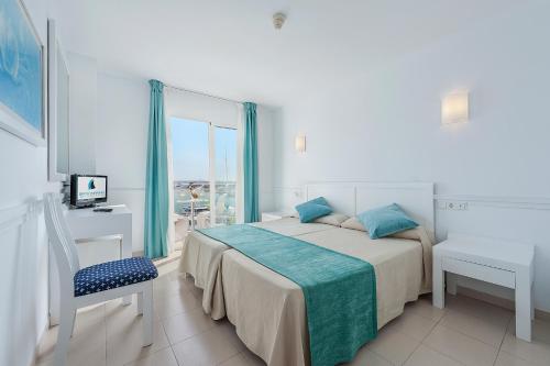 biała sypialnia z łóżkiem i oknem w obiekcie Hostal Brisa Marina w Port d'Alcudia