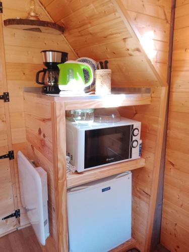 - une petite cuisine dans une petite maison avec un four micro-ondes dans l'établissement La cabane de Moïra, à Xertigny