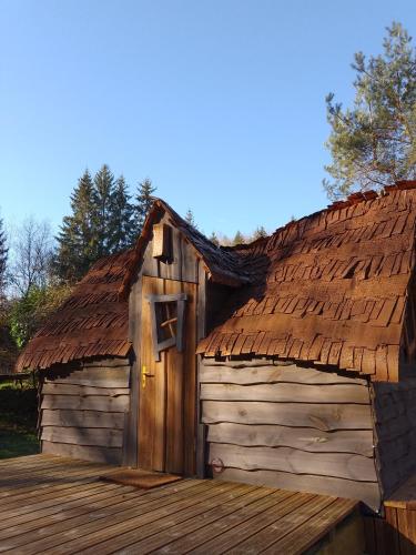 un bâtiment avec un toit et une terrasse en bois dans l'établissement La cabane de Moïra, à Xertigny
