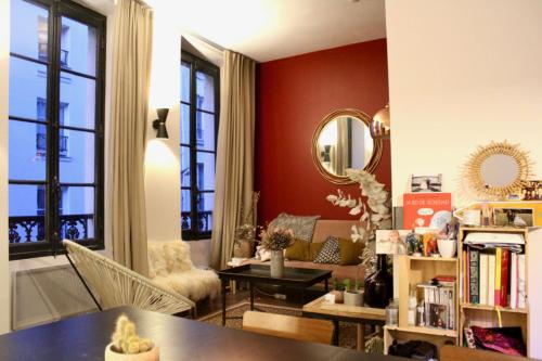 - un salon avec une table et un miroir dans l'établissement Bright and design appt near Grands Boulevards, à Paris